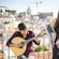 A woman singing with a man playing a Portuguese guitar during a Fado performance in Porto